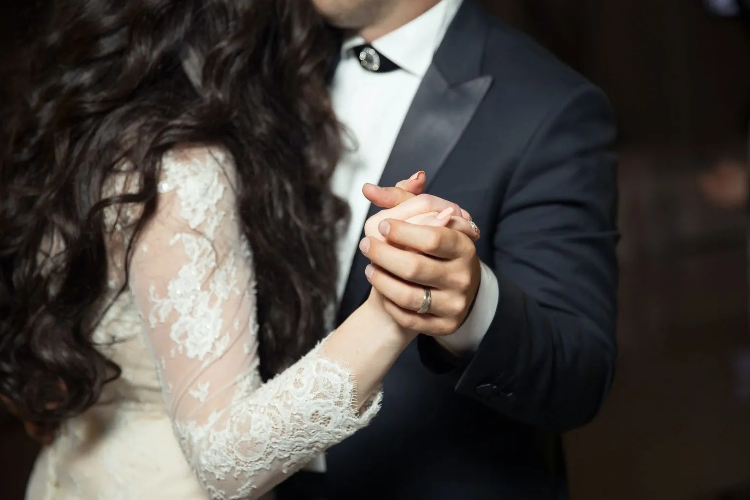 手を取り合って踊るスーツの男性とドレスの女性